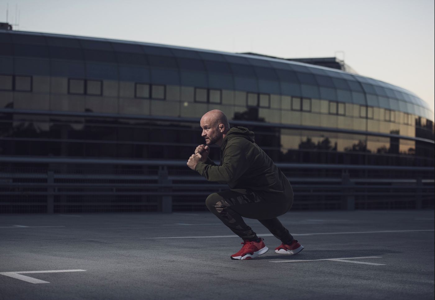 André Walberer in Kampfsporthaltung auf einem Parkdeck – vom Kampfsport zur Energiearbeit